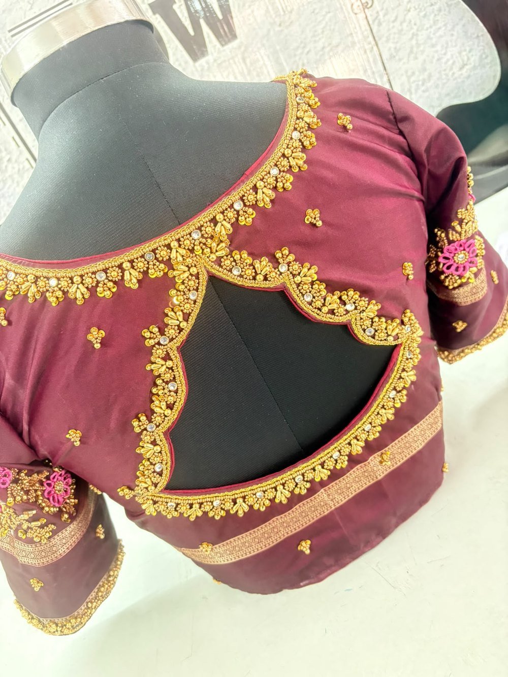 Hand-beaded maroon blouse with gold embroidery detailing, a student creation