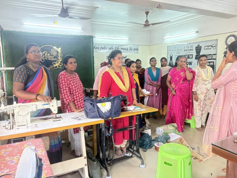 Instructor demonstrating machine-stitching technique to students at Vinu Fashion Academy